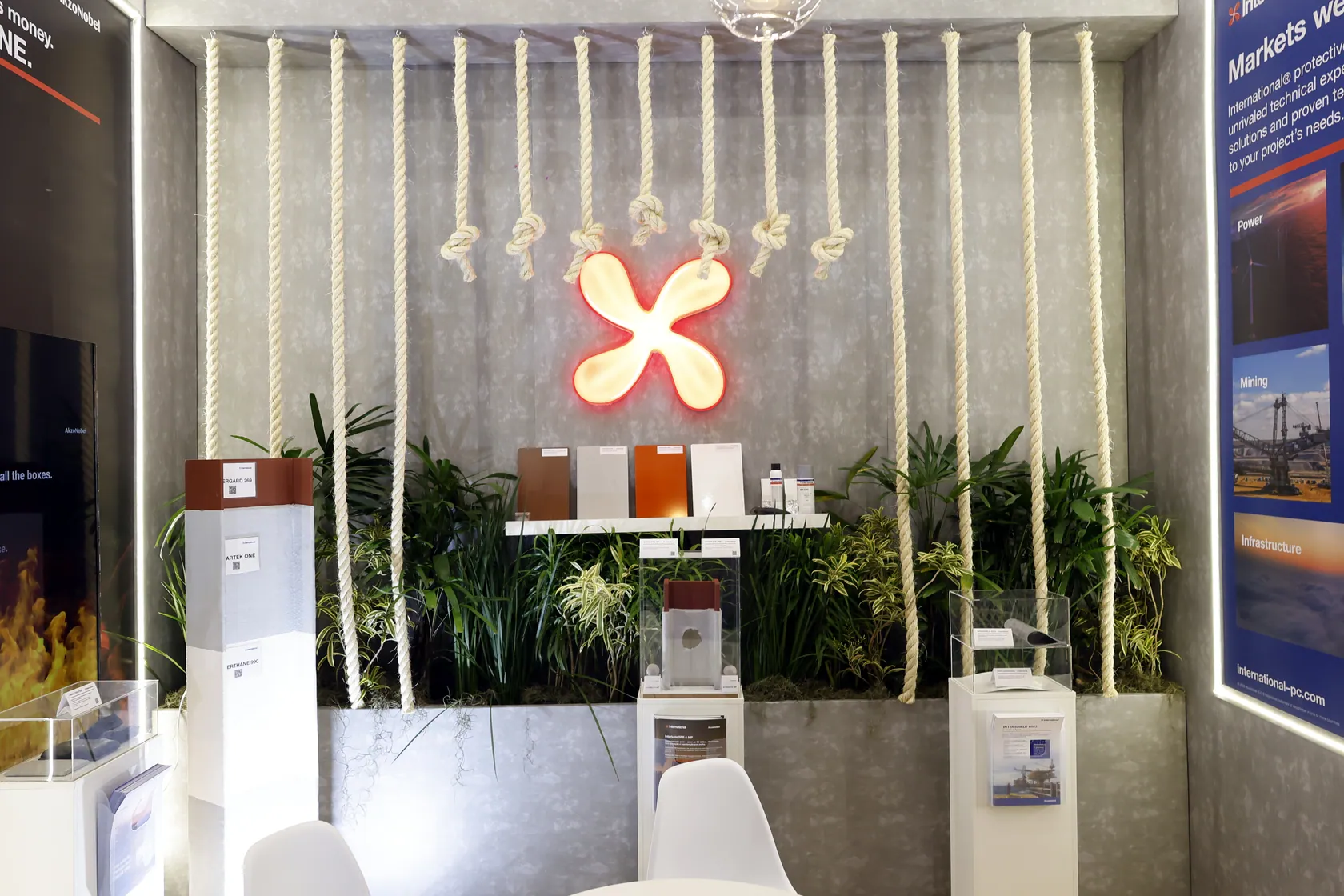 Painel do estande Internacional com iluminação, vegetação e identidade visual